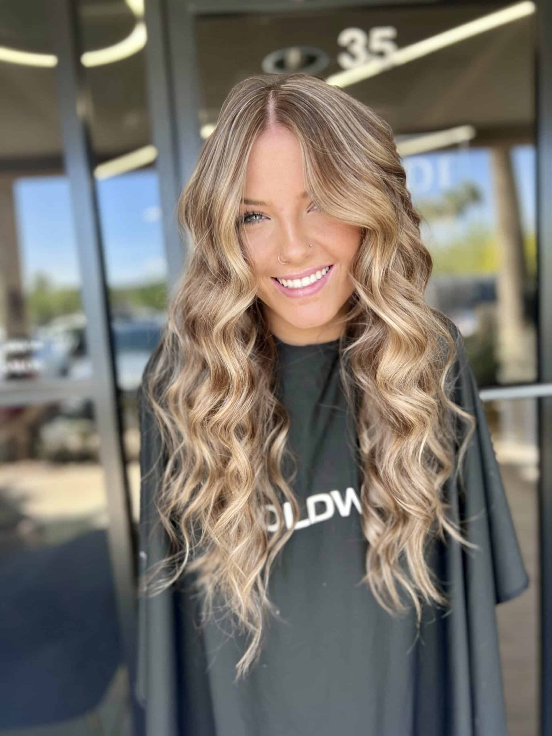 Bright blonde balayage with face framing highlights and soft curls in Chandler AZ