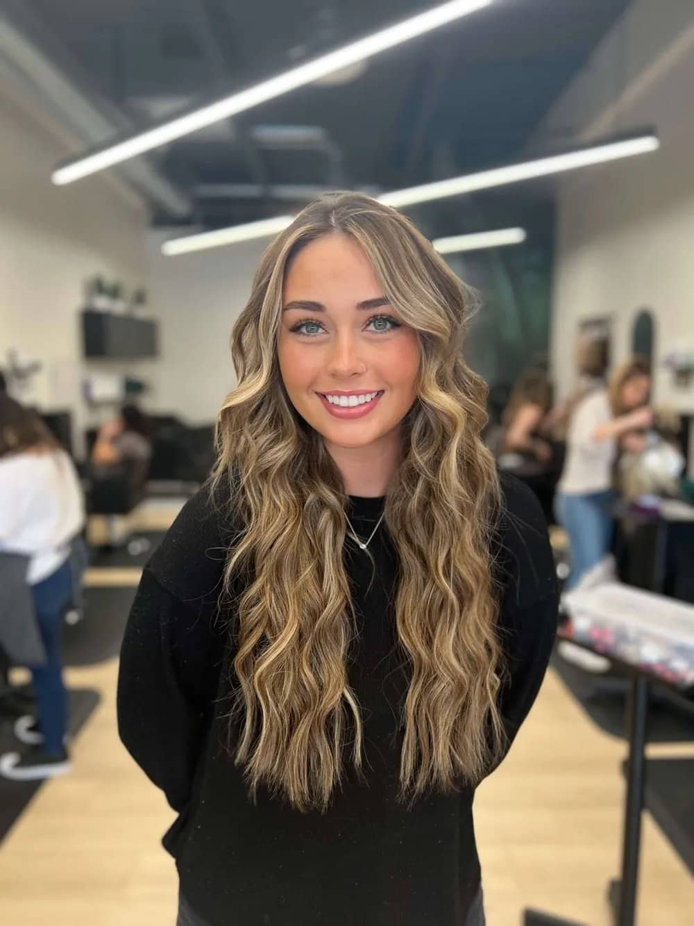 Dimensional blonde balayage with long loose waves and warm tones in Chandler AZ salon